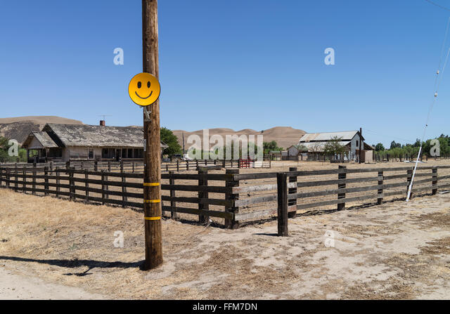 a-yellowish-orange-smiley-face-satellite-antenna-attached-to-a-wooden-ffm7dn.jpg