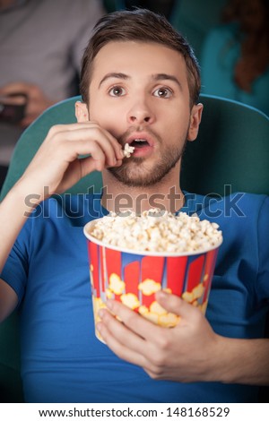 stock-photo-men-at-the-cinema-excited-young-men-watching-movie-at-the-cinema-and-eating-popcorn-148168529.jpg