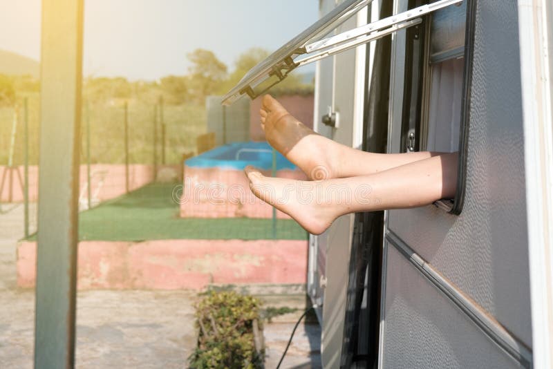 relaxed-woman-sticking-her-feet-out-caravan-window-relaxed-woman-sticking-her-feet-out-caravan-window-228479850.jpg